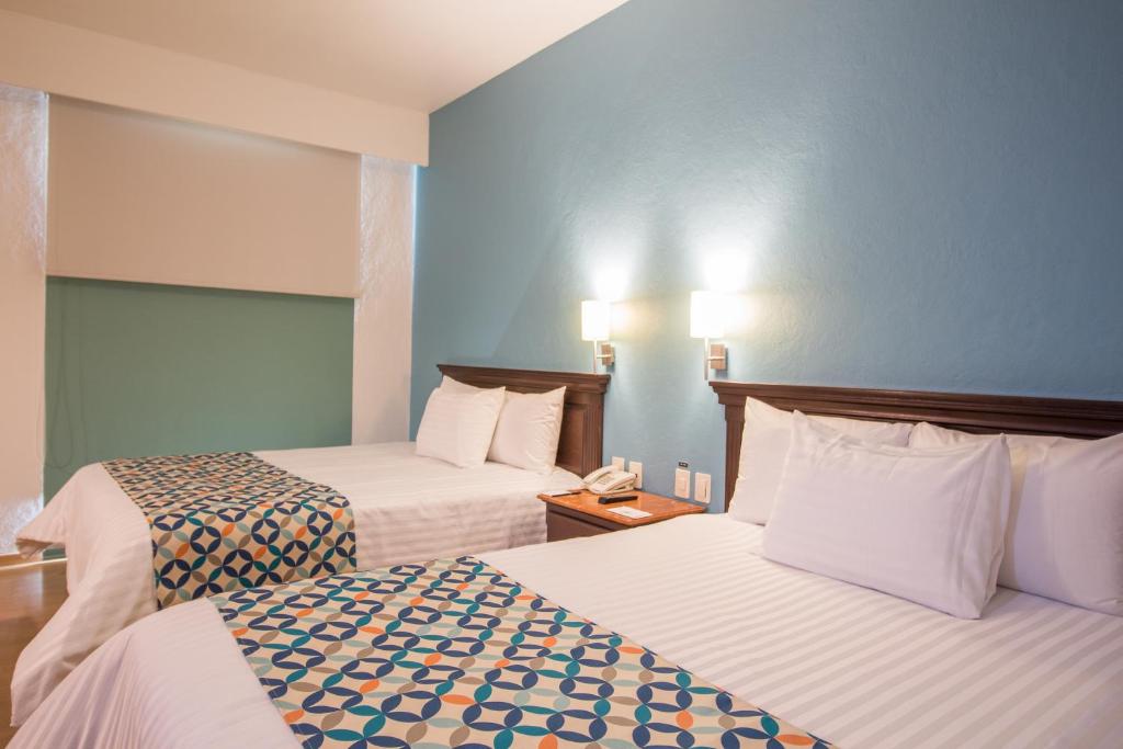 Postel nebo postele na pokoji v ubytování HG Hotel