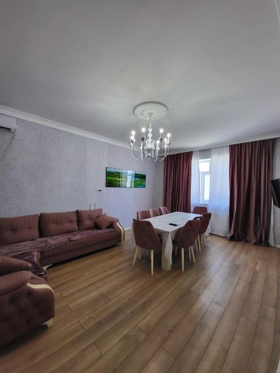 a living room with a couch and a table and chairs at Gabala Deluxe 4-bedrooms Villa in Gabala