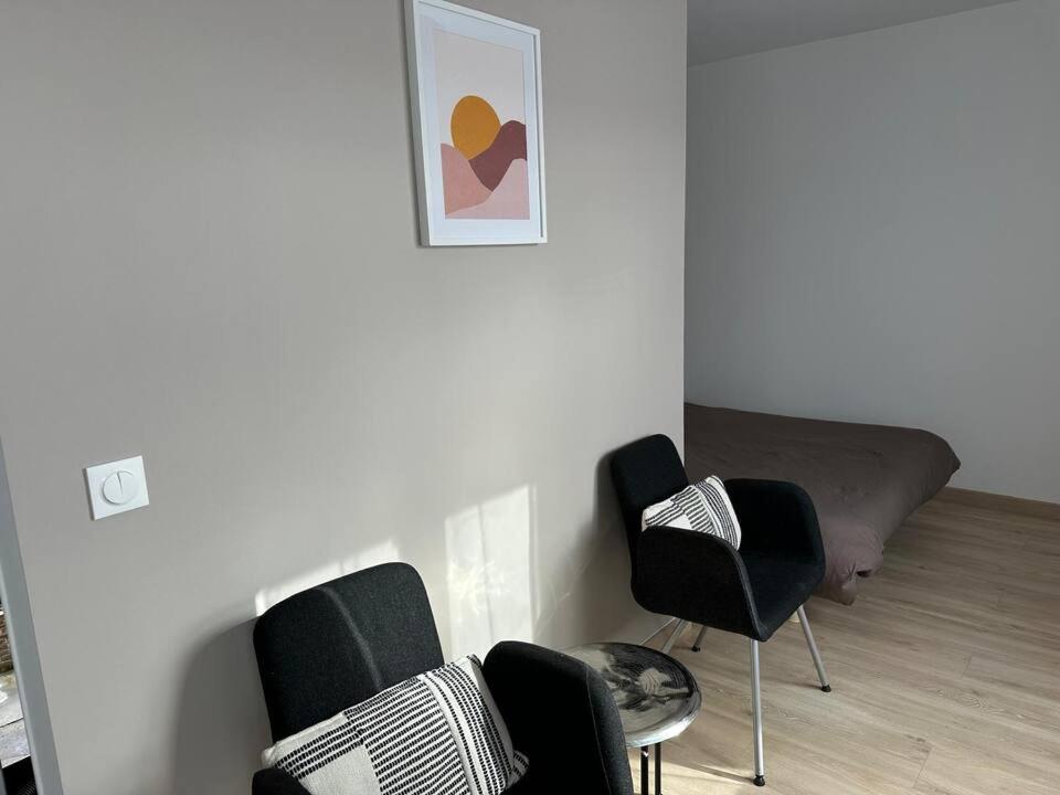 a living room with black chairs and a bed at Studio - Proche Centrex & Disneyland in Noisy-le-Grand
