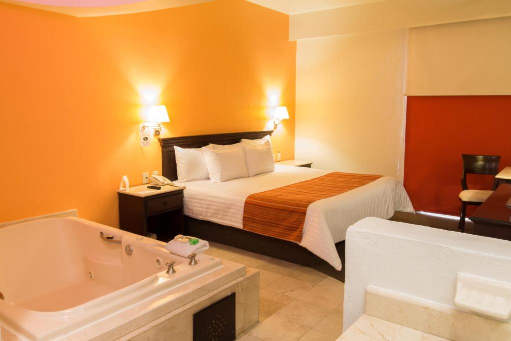 a hotel room with a bed and a bath tub at HG Hotel in Guadalajara