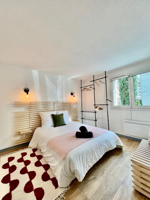 une chambre avec un grand lit et une grande fenêtre dans l'établissement Grenoble, Ile Verte, charme, terrasse et calme, à Grenoble