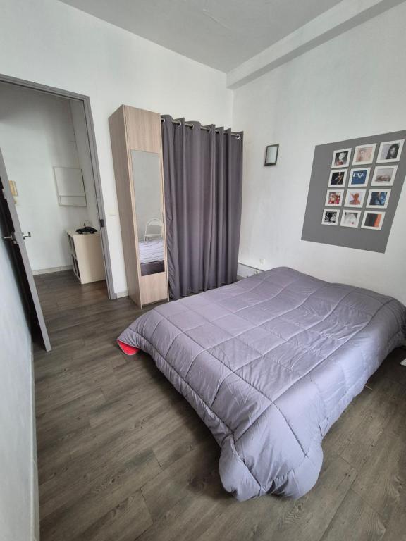 une chambre avec un lit avec une couette violette dans l'établissement Cannes centre - Vieux port, à Cannes