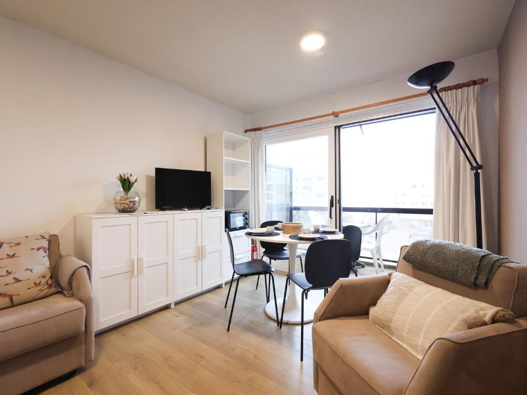 a living room with a couch and a table at Apartment near Belgian Coast Beach in Oostduinkerke