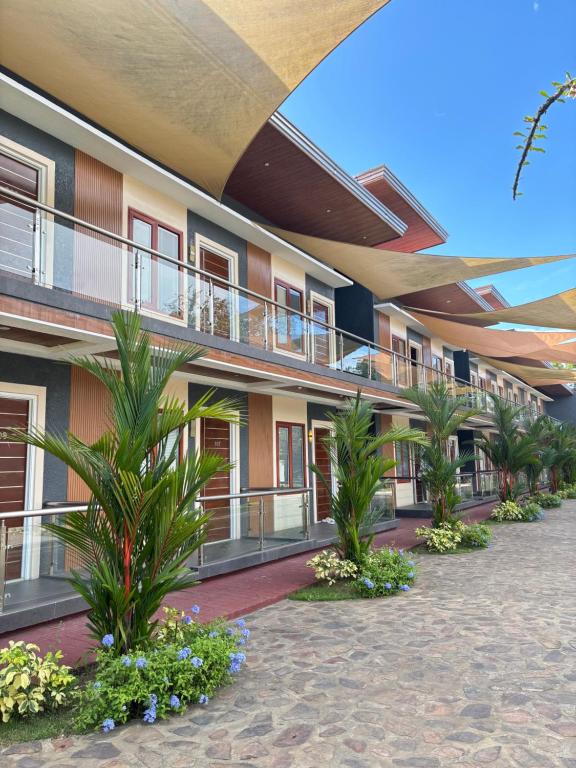 a building with a courtyard with palm trees and plants at Hacienda Angelita Nature Farm and Resort in San Rafael