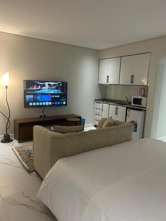 Hotel شقق سمارت أنتري السليمانية 1, a living room with a bed and a couch and a tv at شقق سمارت أنتري السليمانية 1 in Riyadh