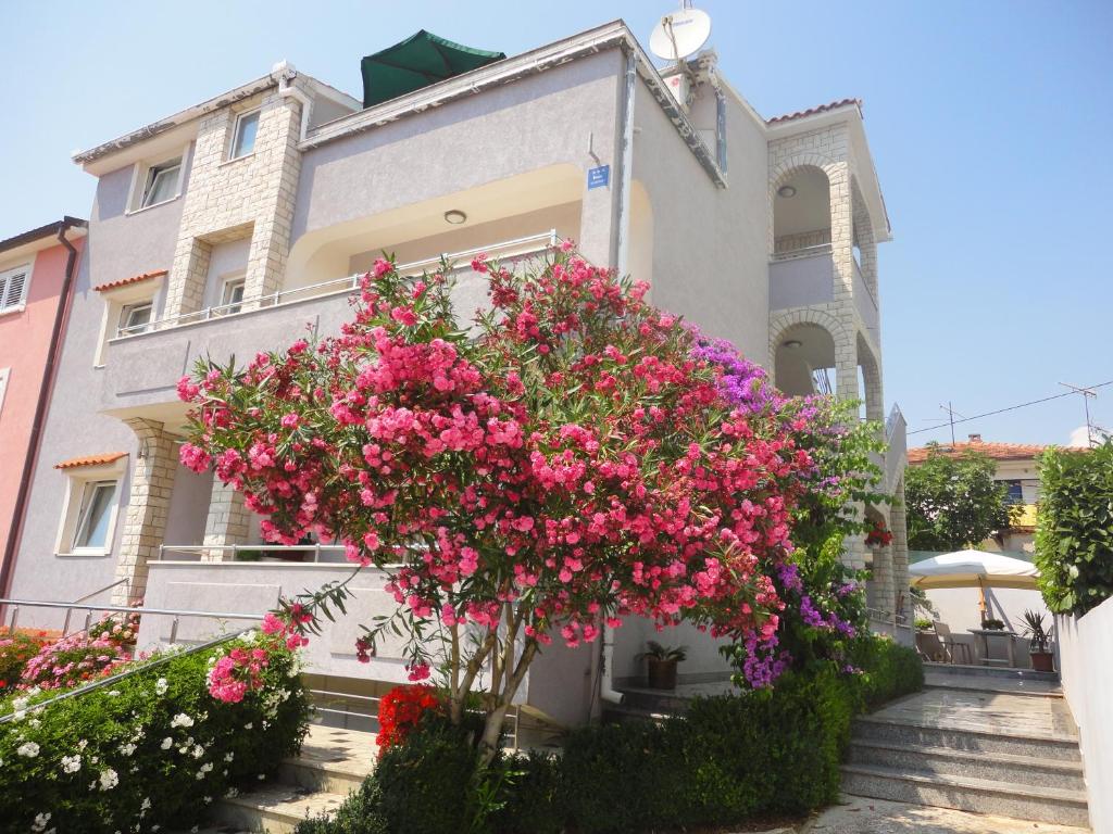 Un edificio con flores rosas en el frente. en Pejić Apartments, en Pula