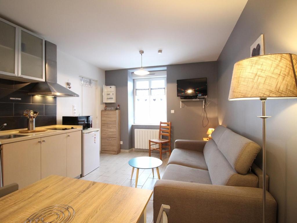 un salon et une cuisine avec un canapé et une table dans l'établissement Studio RDC avec WiFi proche centre Mont-Dore - 2 couchages - 2 étoiles - Équipé et tout confort - FR-1-415-108, à Le Mont-Dore