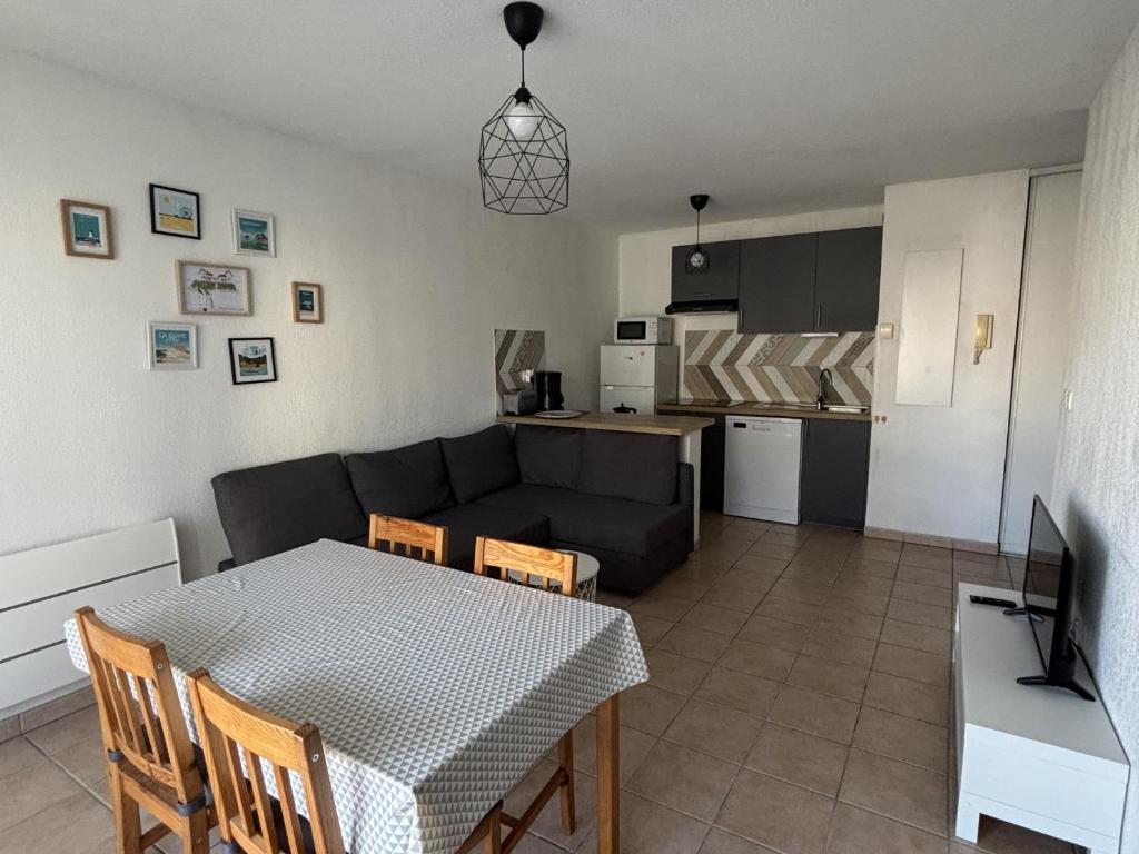 - un salon avec une table et un canapé noir dans l'établissement Appartement T2 avec piscine à Biscarrosse Bourg, proche plages du lac et océan, 4 pers, centre-ville - FR-1-319-454, à Biscarrosse