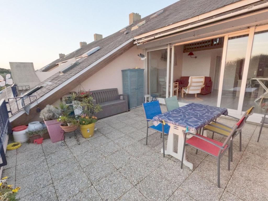 une terrasse avec une table et des chaises dans une maison dans l'établissement Duplex T4 rénové à Arzon, 5 pers, proche plage - FR-1-775-19, à Arzon