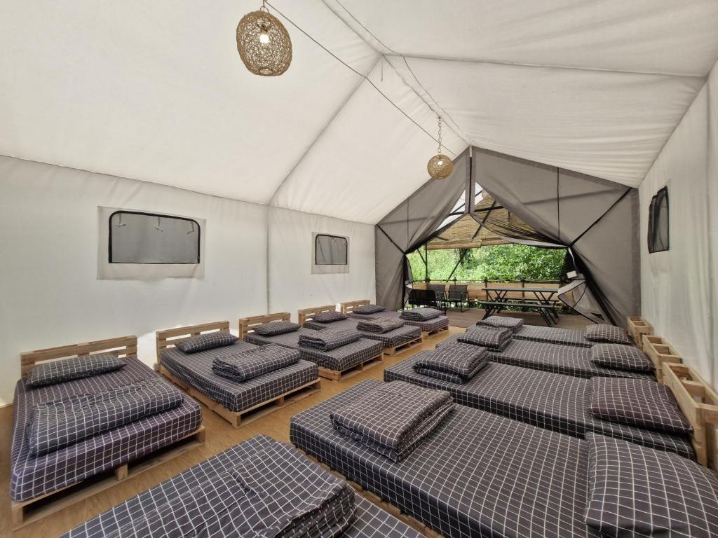 una habitación con filas de camas en una tienda de campaña en Green Hill Park Ciwidey, en Baruhtunggul