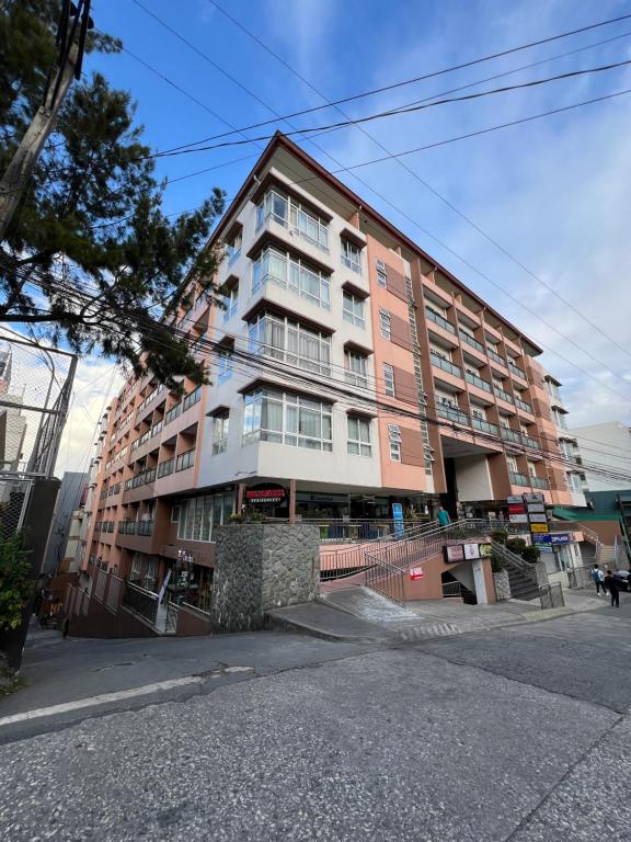 a large apartment building on the side of a street at Oyasumi Condotel with balcony-Megatowers 1 Near Session, SM, Burnham park, Baguio City in Baguio