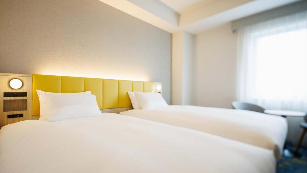 Postel nebo postele na pokoji v ubytování JR-East Hotel Mets Tachikawa