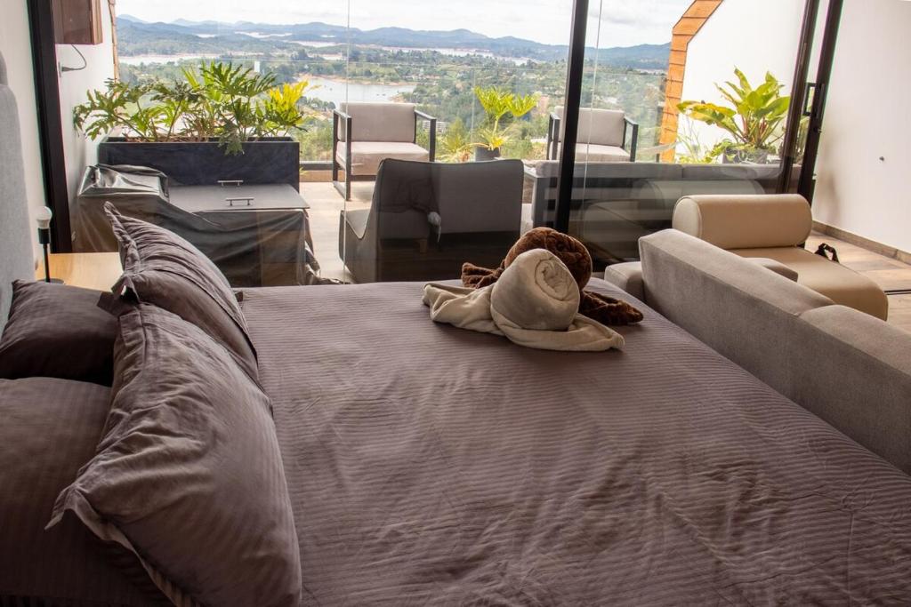 a large bed in a room with a large window at Luxury Guatapé Loft with Starlink WiFi & Jacuzzi in Chiquinquirá