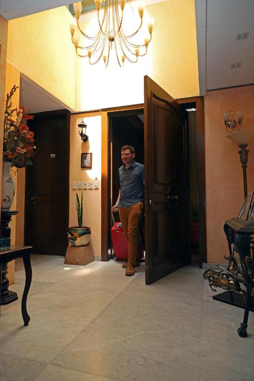a man standing in an open door in a room at Casa de Huéspedes en Satélite - Boutique Rosas in Mexico City