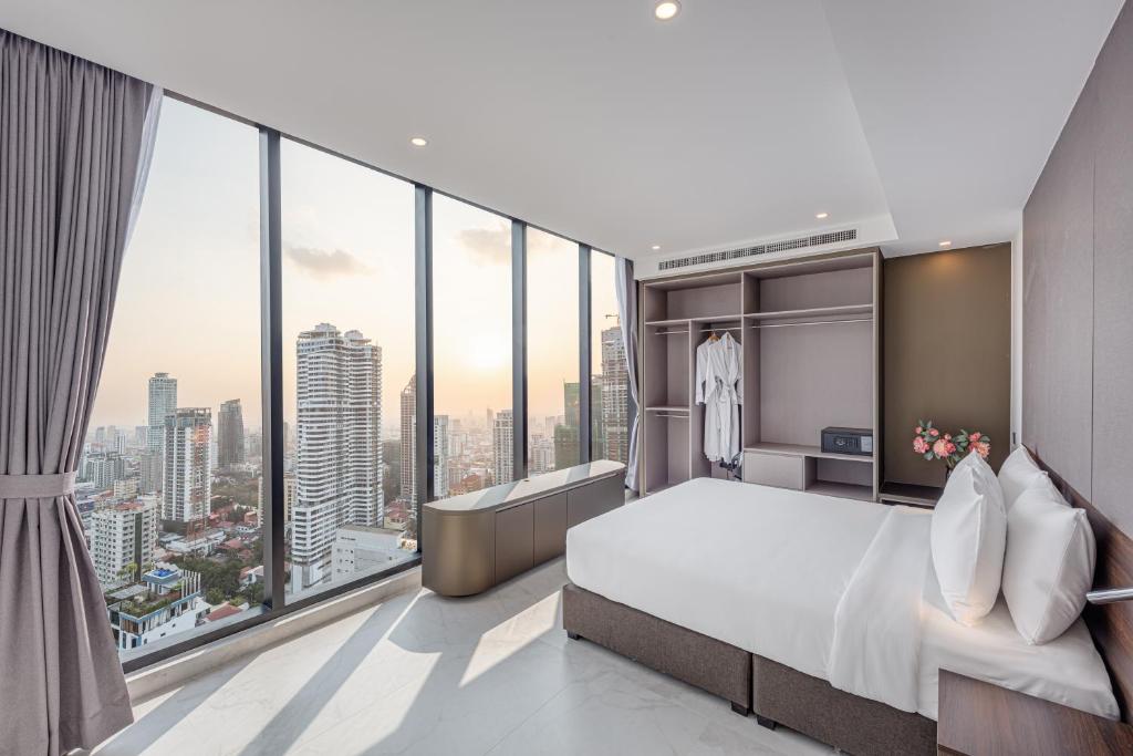 Un dormitorio con una cama grande y grandes ventanales. en Grand Mansion, en Phnom Penh