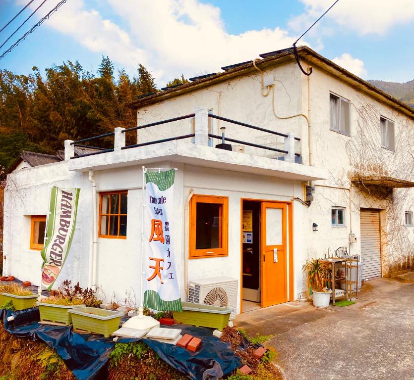 a white house with an orange door at farm stay Jammin in Itoshima