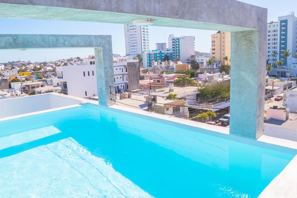 a swimming pool in a building with a view of a city at Loft a 3 cuadras de la playa by G P S rentas in Mazatlán