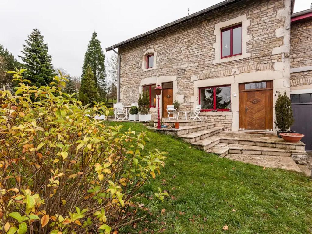 a stone house with a door and a yard at Séjour de charme au cœur de la campagne meusienne - FR-1-585-152 in Vouthon-Haut