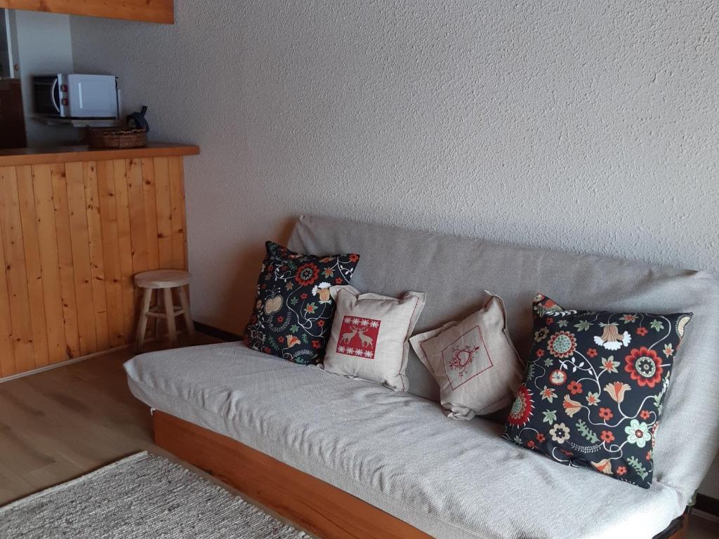 un canapé avec des coussins dessus dans un salon dans l'établissement Studio Mezzanine 4 Pers, Parking, Près Centre Châtel - FR-1-676-213, à Châtel