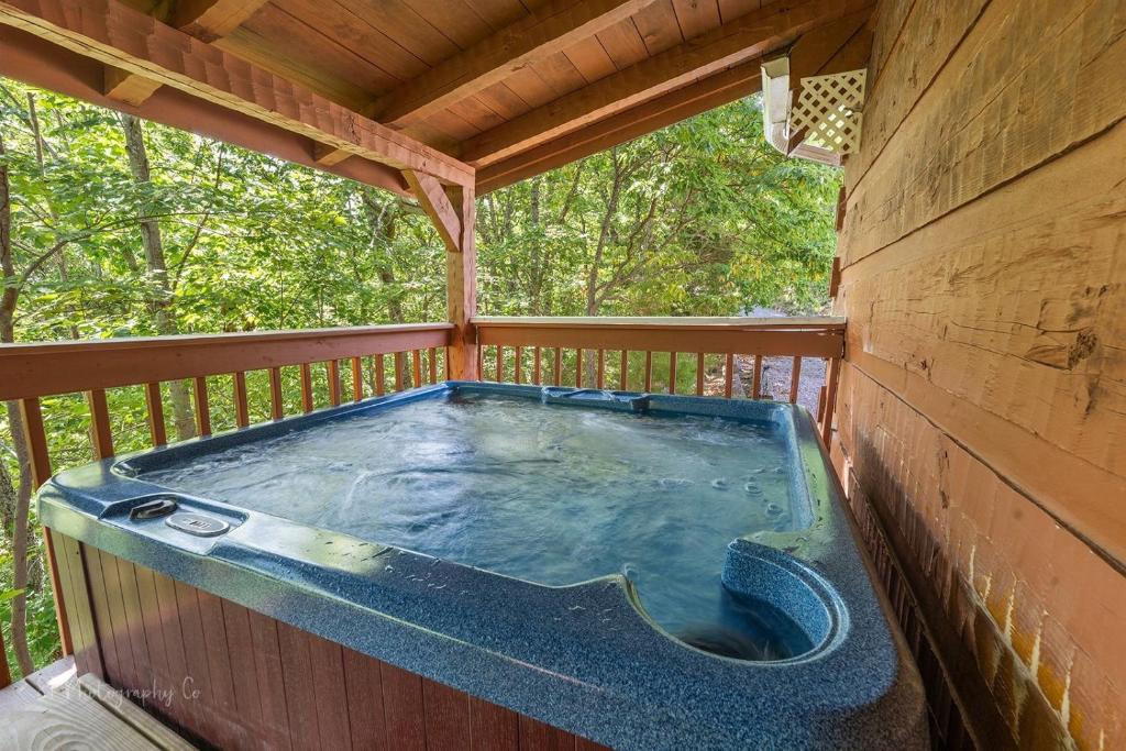 a hot tub on the deck of a tree house at Sweet Scarlet Rose cabin in Sevierville