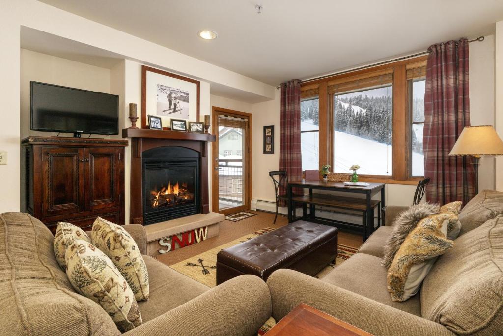 a living room with a couch and a fireplace at Select Unit 2509 - Zephyr Mountain Lodge condo in Winter Park