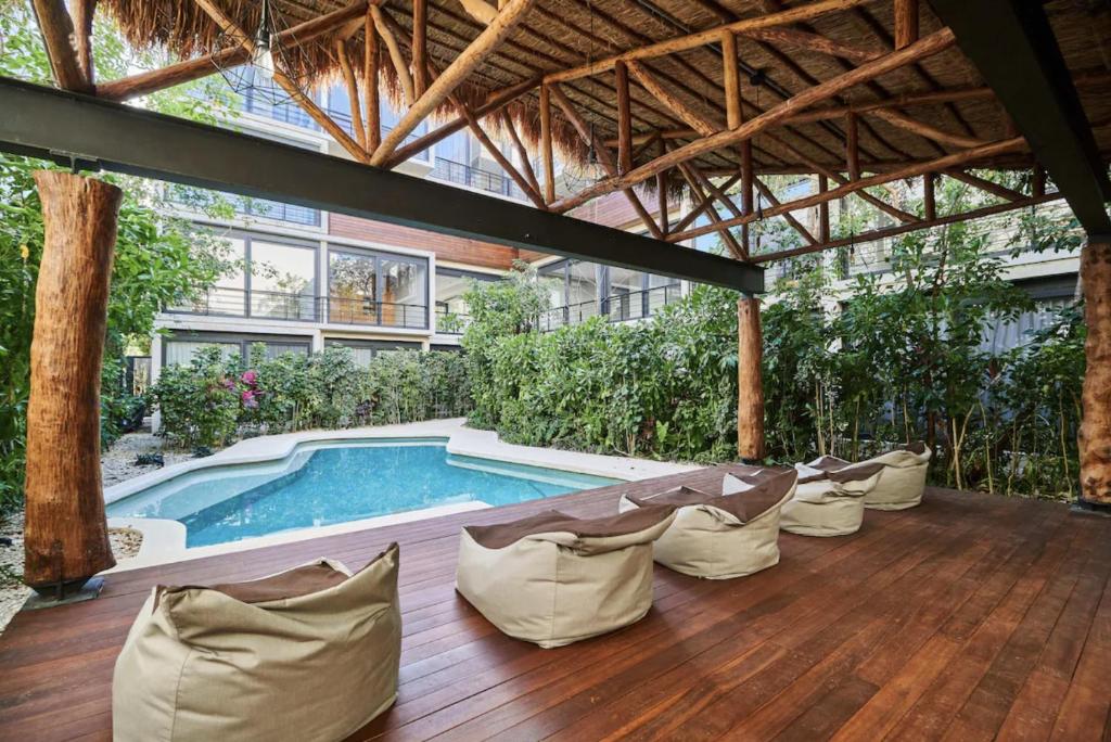 an outdoor patio with chairs and a swimming pool at Xielo in Tulum