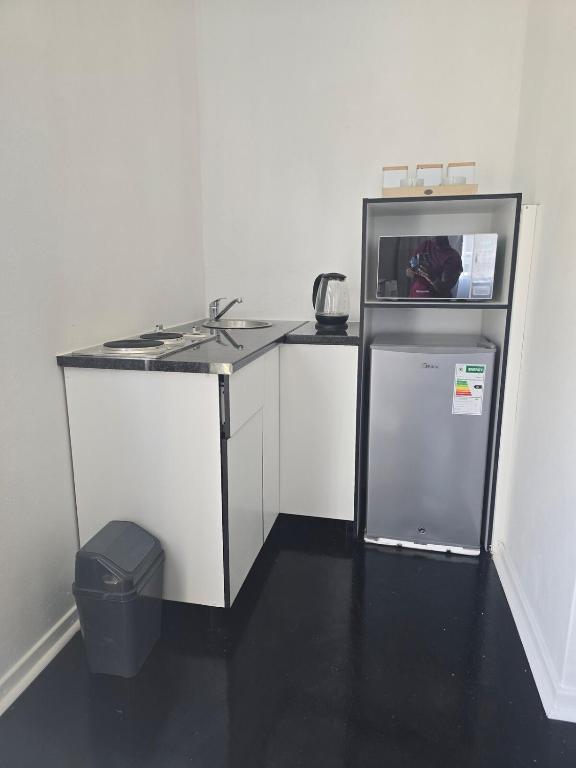 a small kitchen with a counter and a refrigerator at Majhiya on Ferndale apt in Gqeberha