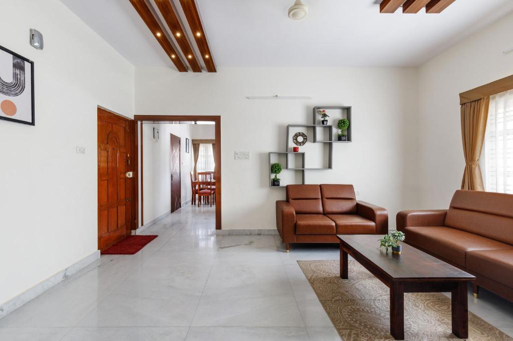 a living room with two couches and a coffee table at Mistyblue Suites in Bengaluru