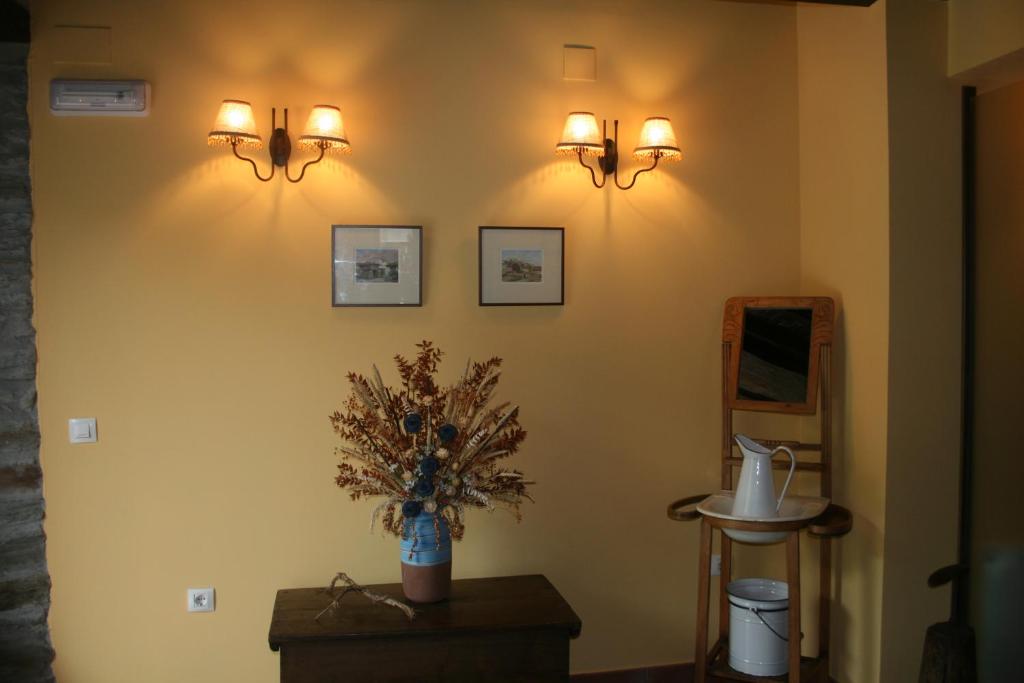 a room with two lights and a vase of flowers on a wall at Apartamentos Rurales El Palacio de Doiras in Boal