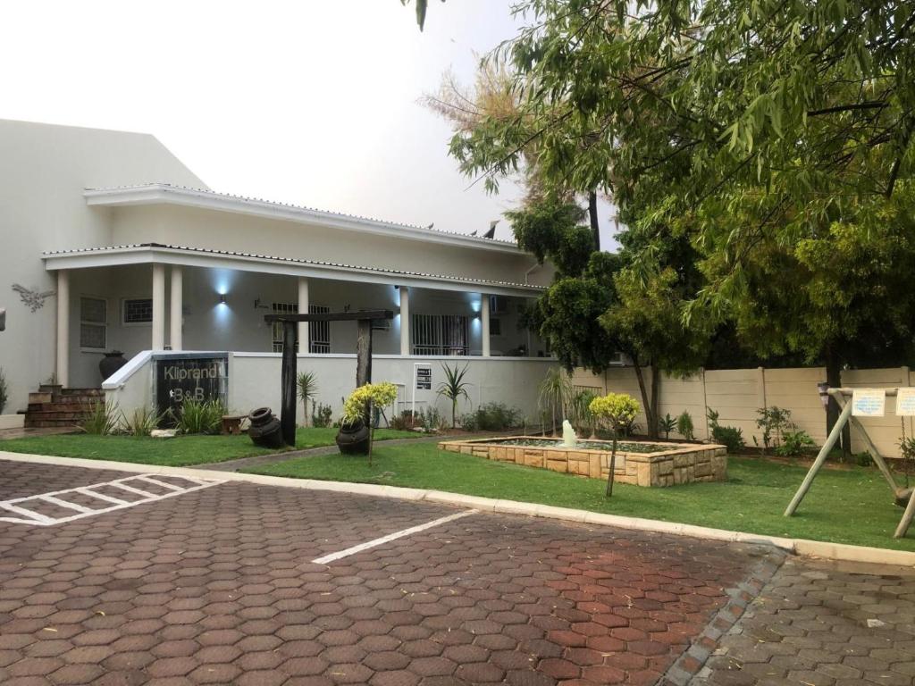 ein Haus mit einer gepflasterten Auffahrt davor in der Unterkunft Kliprand Guest House in Springbok