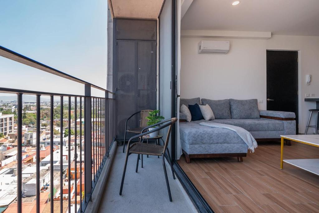 a bedroom with a bed and a couch on a balcony at MiLi's home, comodidad y ubicación en Guadalajara in Guadalajara