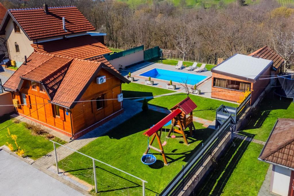una vista aerea di una casa con parco giochi di Timber Cottage With Pool - Happy Rentals a Zasadbreg