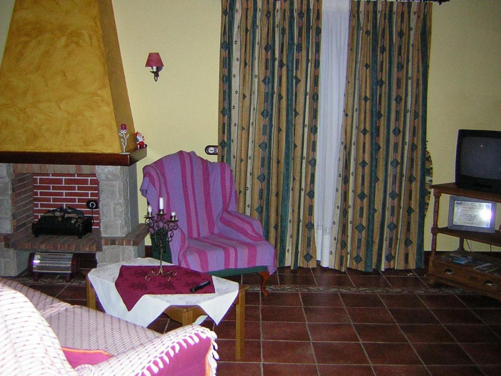 a living room with a chair and a fireplace at Villa Caya in La Orotava