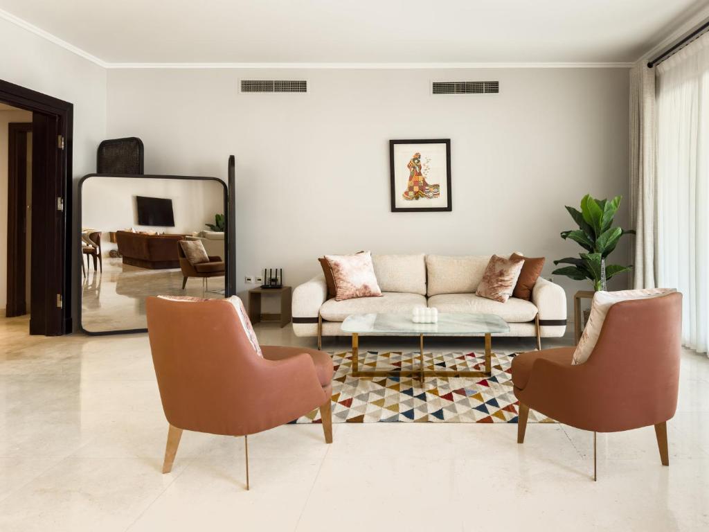 ein Wohnzimmer mit einer Couch und zwei Sesseln in der Unterkunft Sunny Cairo City Center l Serviced l Golf l Pool l Gym l 2 in Kairo