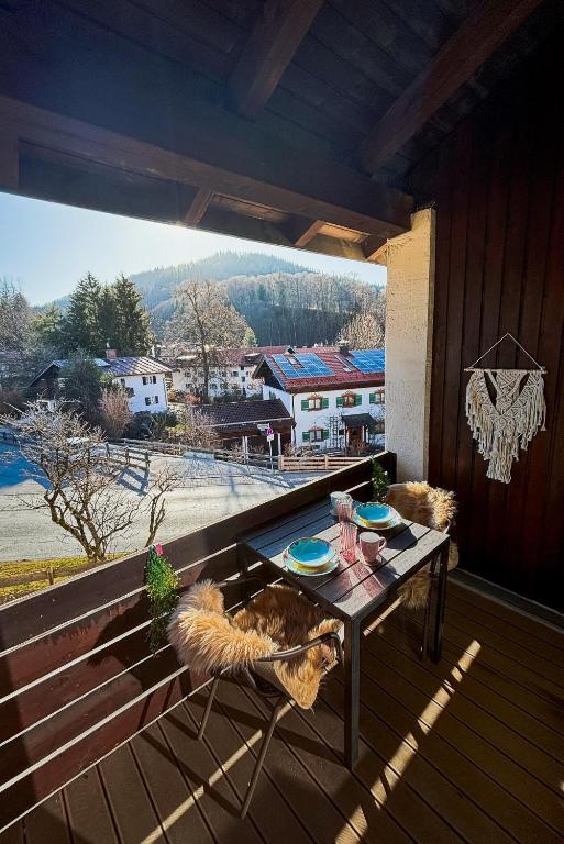 einem Hund, der auf einem Stuhl auf einer Terrasse mit einem Tisch sitzt in der Unterkunft Zentrales Apartment mit Balkon direkt am Wanderweg - Alpenperle Tegernsee in Tegernsee