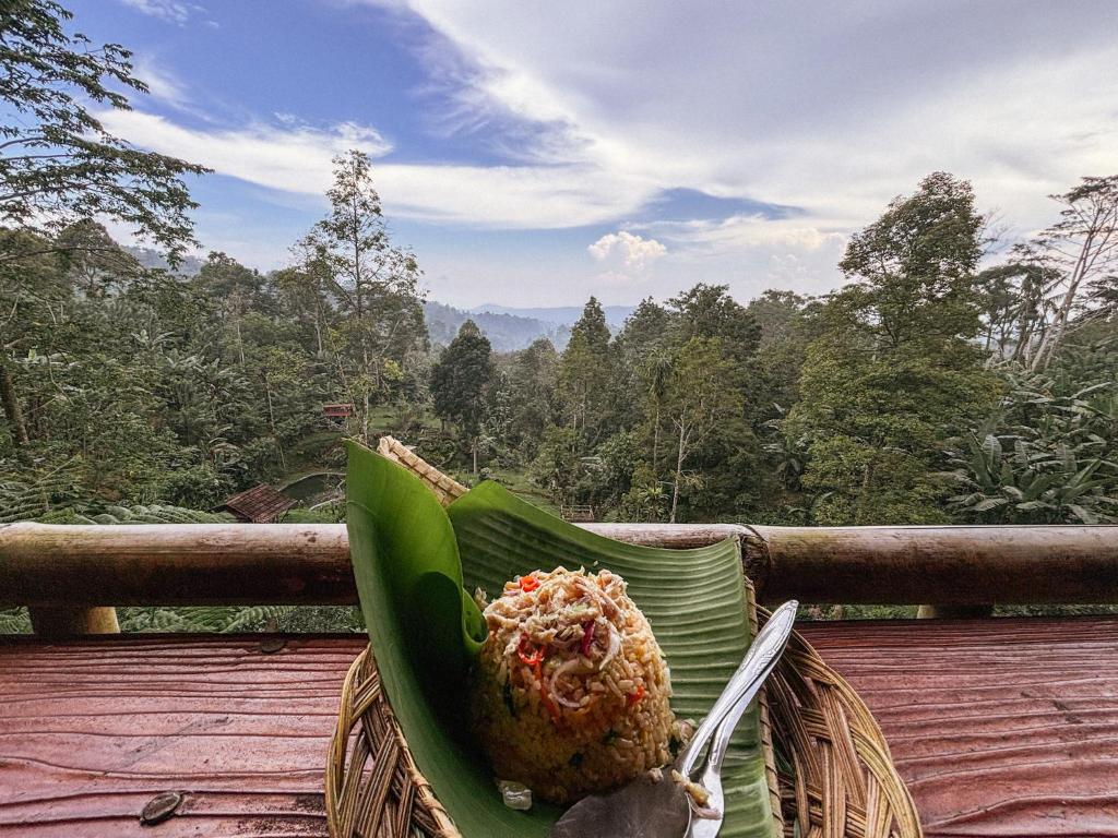 una ciotola di cibo su una foglia di banana su un ponte di Sanda Eco Cabins by AGATA a Padangan
