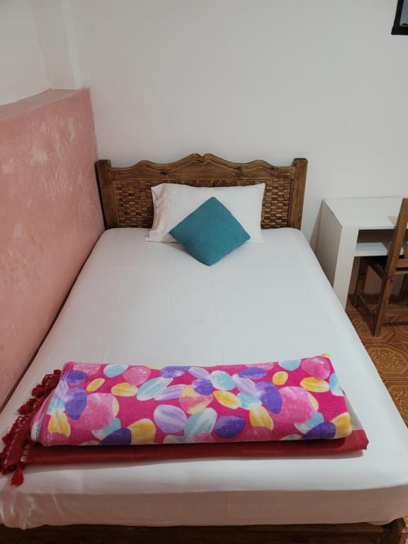 ein weißes Bett mit einer bunten Decke drauf in der Unterkunft Dpto Cómodo Barrio Guadalupe Céntrico con Estac y FREE WIFI in San Cristóbal de las Casas