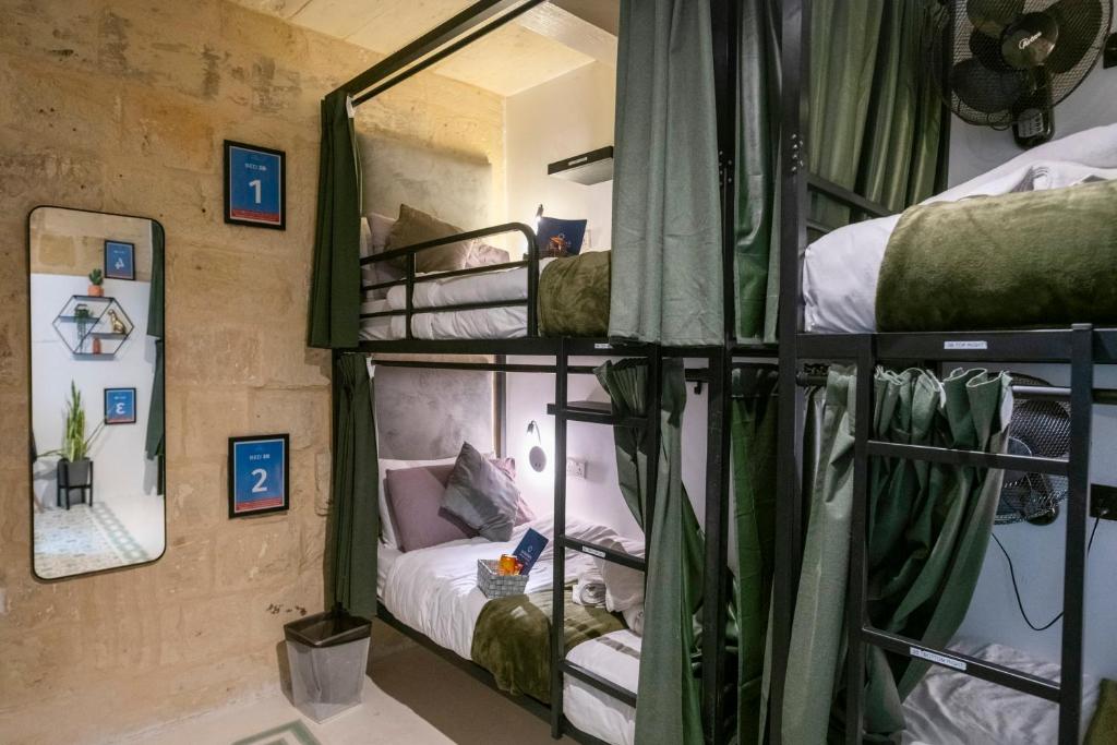 a room with three bunk beds in a room at Mandera's Boutique Suites & Dorms in Valletta