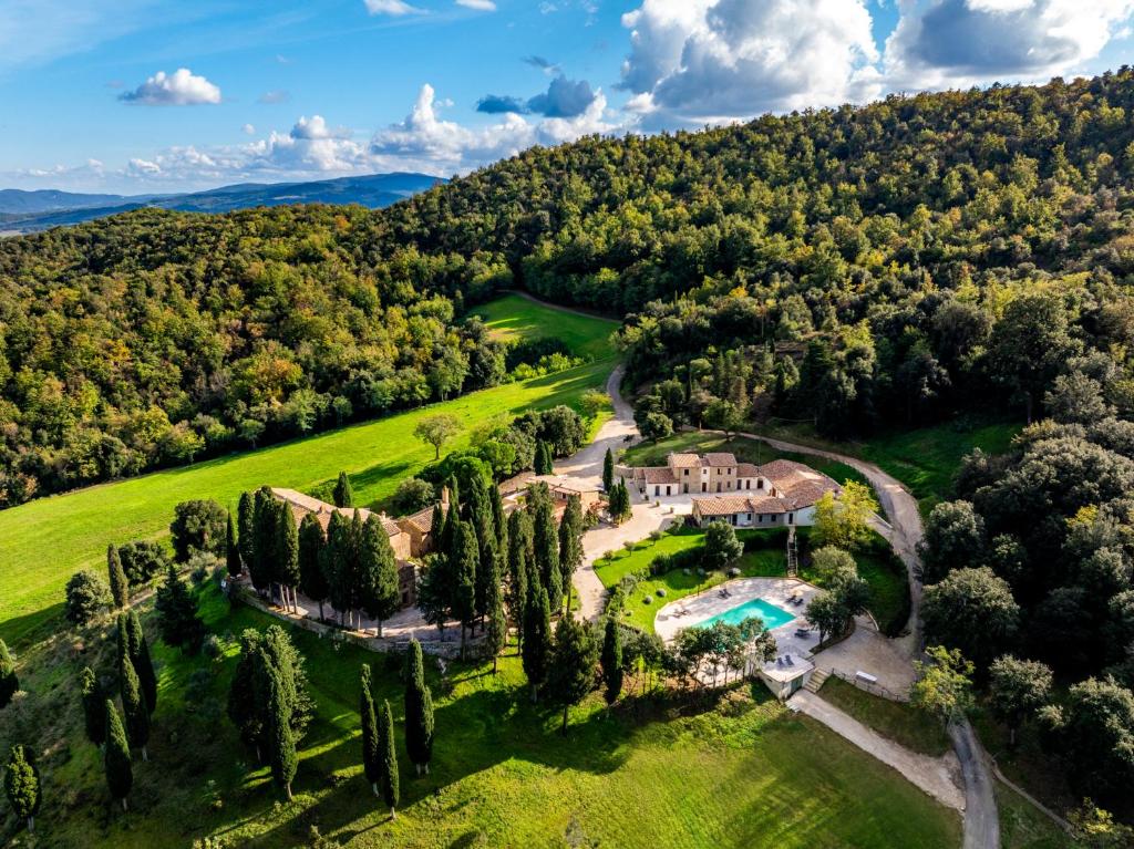 an aerial view of a mansion with a pool and trees at Tenuta La Farneta in Casole dʼElsa