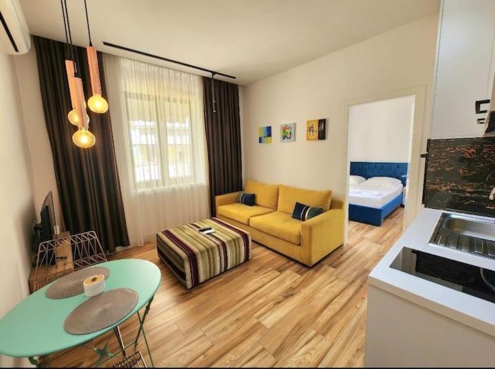 una sala de estar con un sofá y una mesa en Central City Apartments, en Tirana