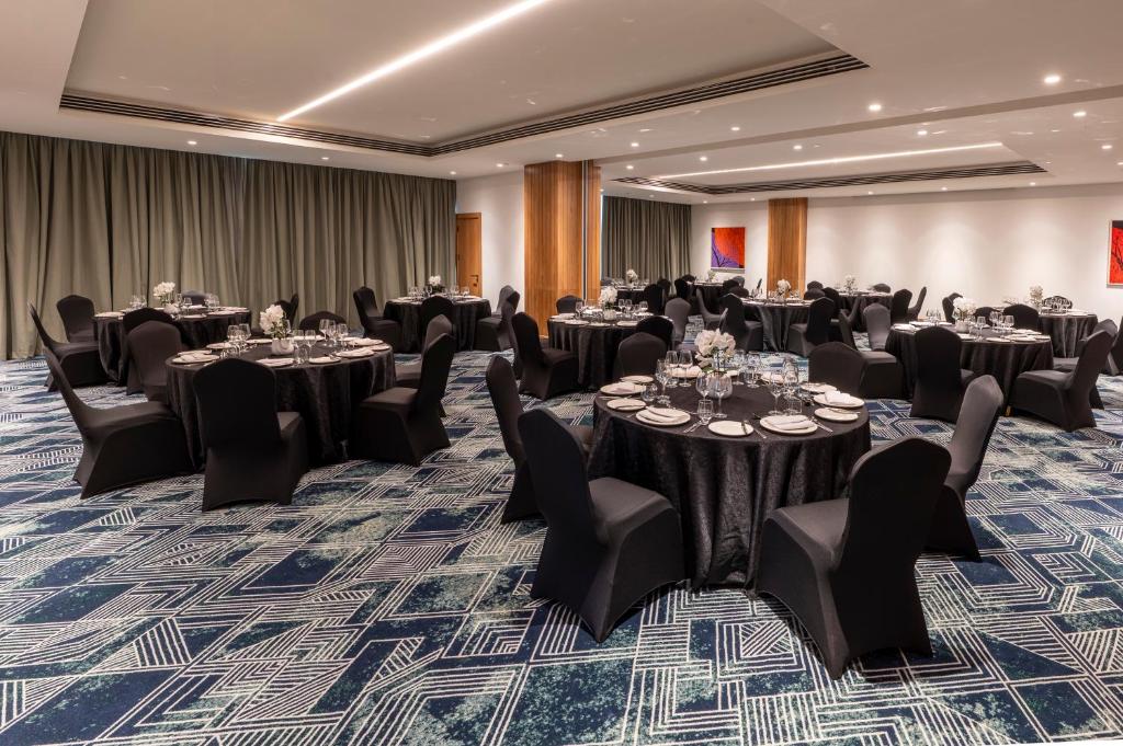 una sala da ballo con tavoli e sedie in una stanza di Hyatt Place Nairobi Westlands a Nairobi