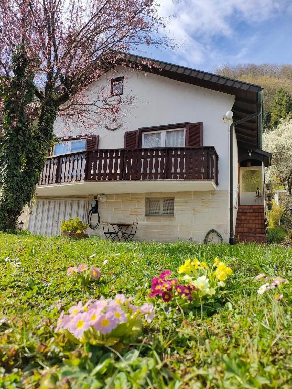 a house with a balcony and flowers in the yard at Palmehüüsle in Herten