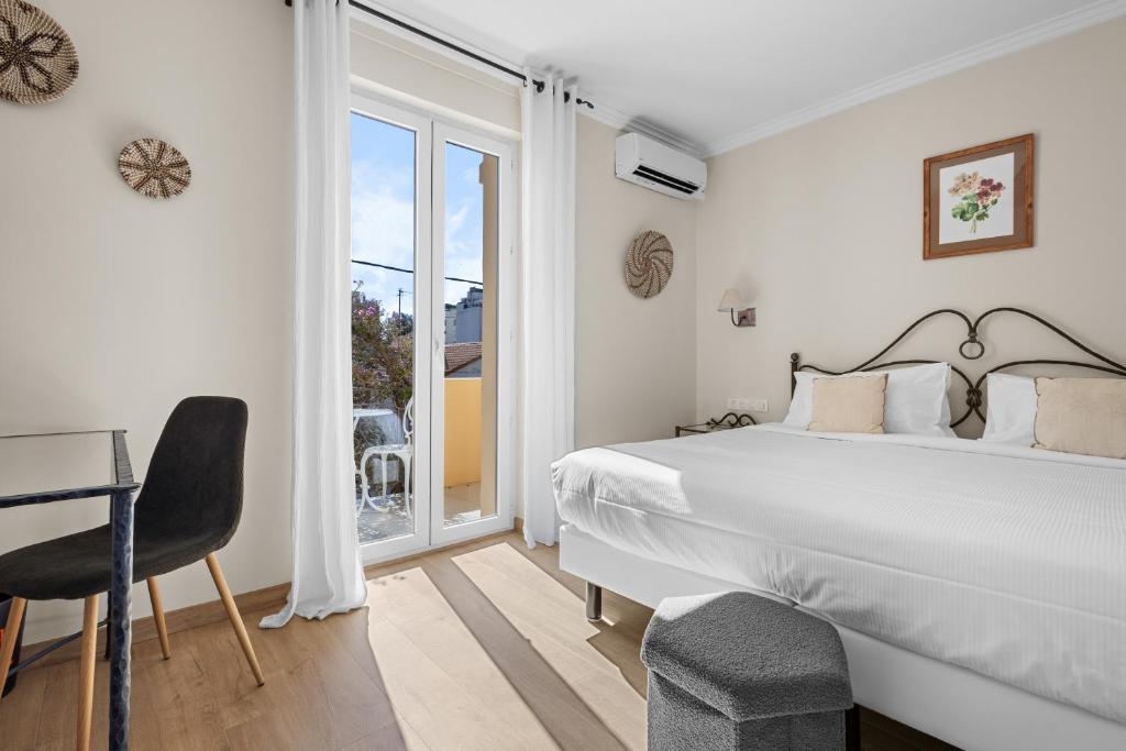 a bedroom with a bed and a desk and a window at Hôtel La Villa Sainte Valérie Adults Only in Juan-les-Pins