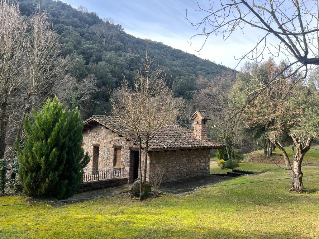 an old stone house in the middle of a field at Molí d'en Puig in Vall de Bianya