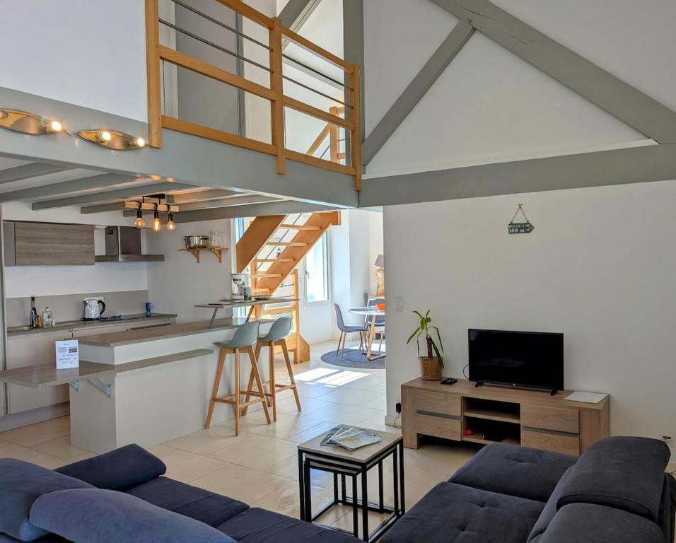 un salon avec un canapé et une cuisine dans l'établissement Élégante Maison de ville, à Pornic