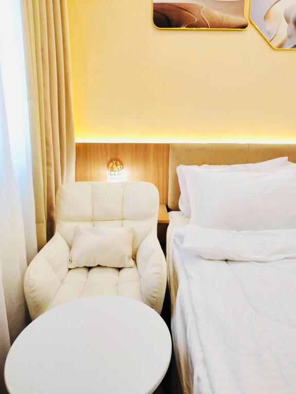 ein Zimmer mit zwei Betten und einem Stuhl in der Unterkunft Morena Suite,Staycation,WiFi,Netflix,Near DLSU & Malls in Dasmariñas