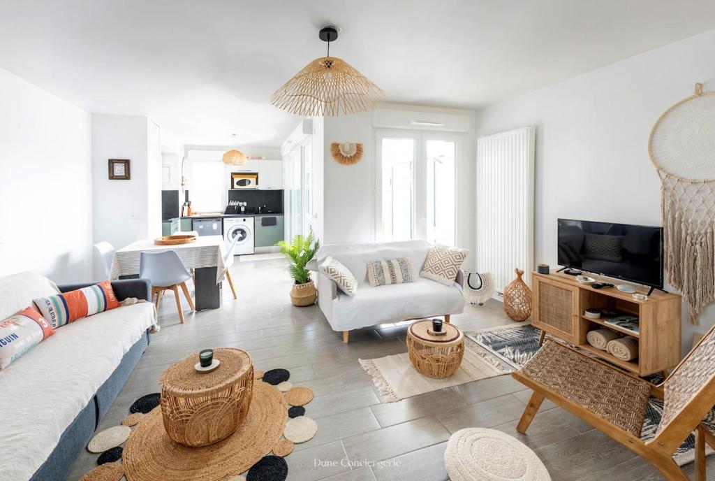 un salon avec un canapé et une table dans l'établissement Le Logis du Bassin - Meublé 3 étoiles, à Arcachon