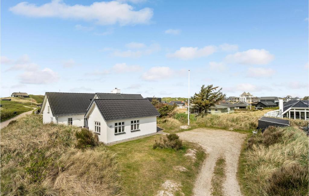 a white house on a hill with a dirt road at Holiday Home Plantagevej Ringkøbing Xii in Søndervig