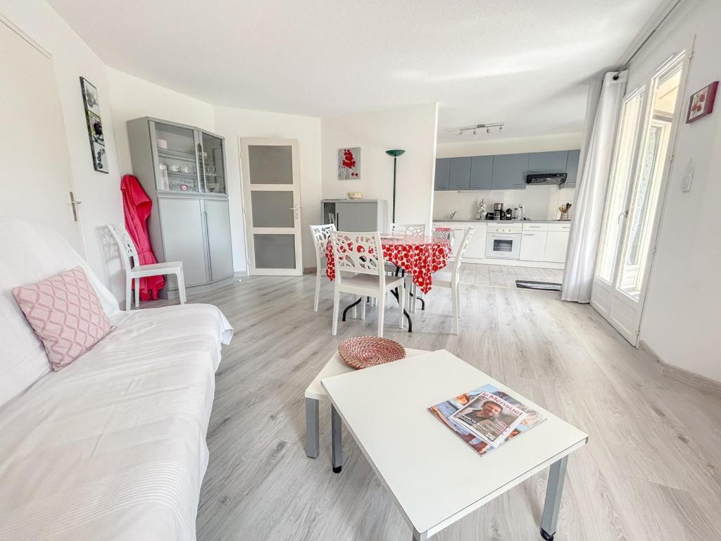 un salon avec un canapé blanc et une table dans l'établissement F2 avec terrasse et parking privé à Fréjus, à Fréjus