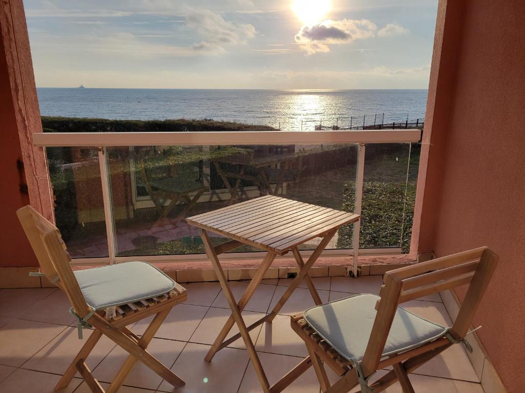 une table et des chaises sur un balcon avec vue sur l'océan dans l'établissement Beau T3 au calme, vue mer imprenable, à Sète